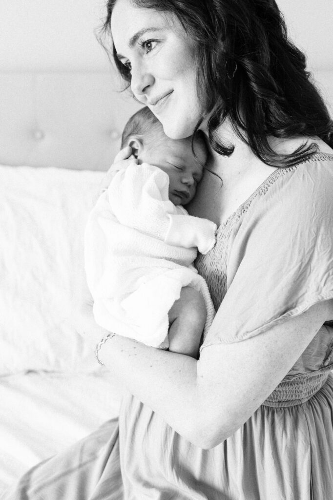 Mother holding newborn close during an in-home lifestyle session