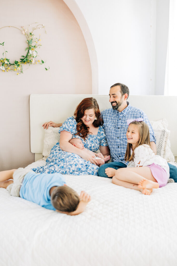 Family together with newborn in the master bedroom during a lifestyle session in Columbia South Carolina
