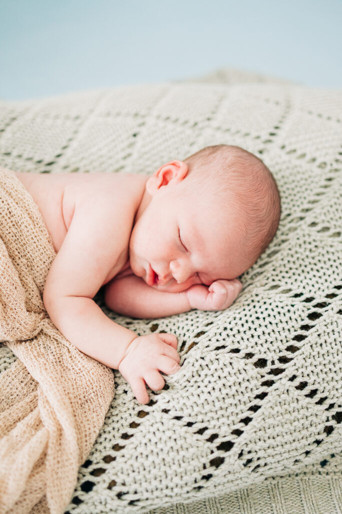Close-up of newborn baby sleeping during photo session by Carters Creative.