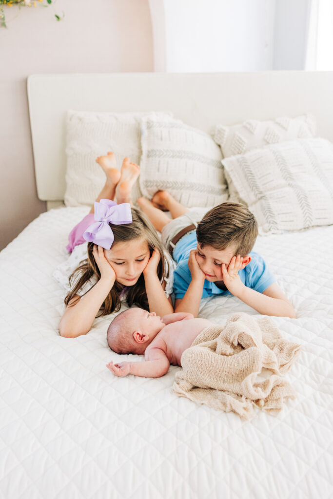 Older siblings with newborn baby during an in-home lifestyle session.