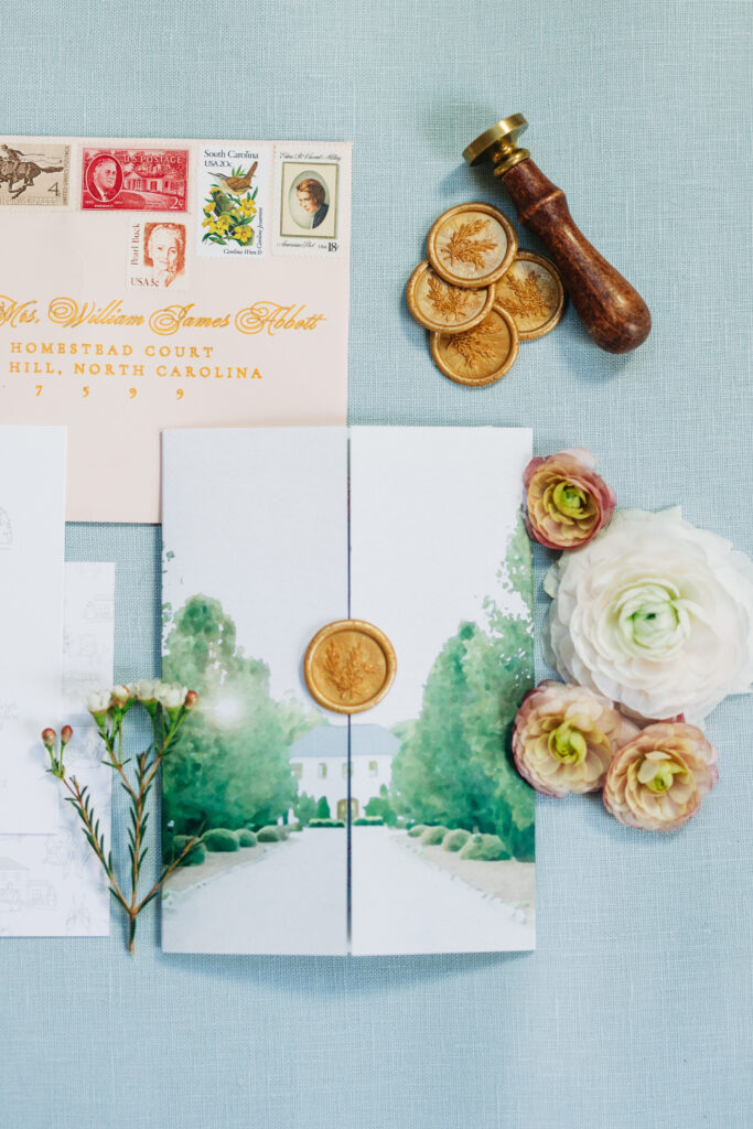 Close up of wedding invitation with wax seal, stamps and pressed flowers