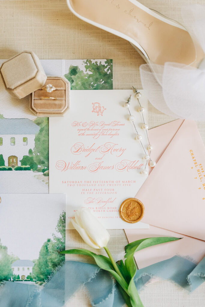 Close-up of wedding invitation and detail card styled on flat lay board