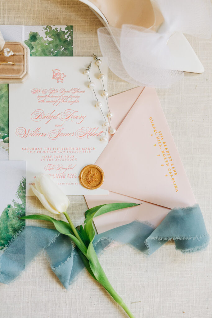 Close-up of wedding invitation with wax stamp seal.