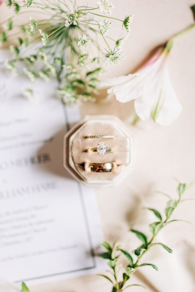 Close up of wedding rings and wedding invitation by Carter's Creative
