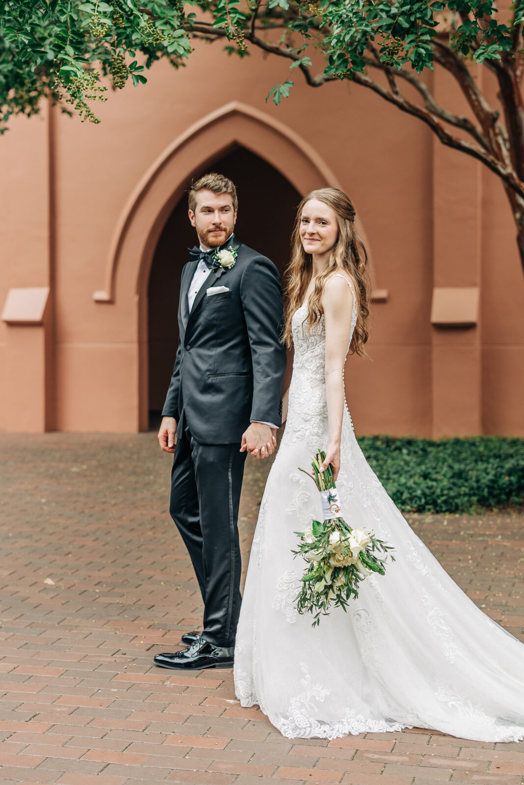 Bride and groom holding hands outside a church during their Charleston wedding