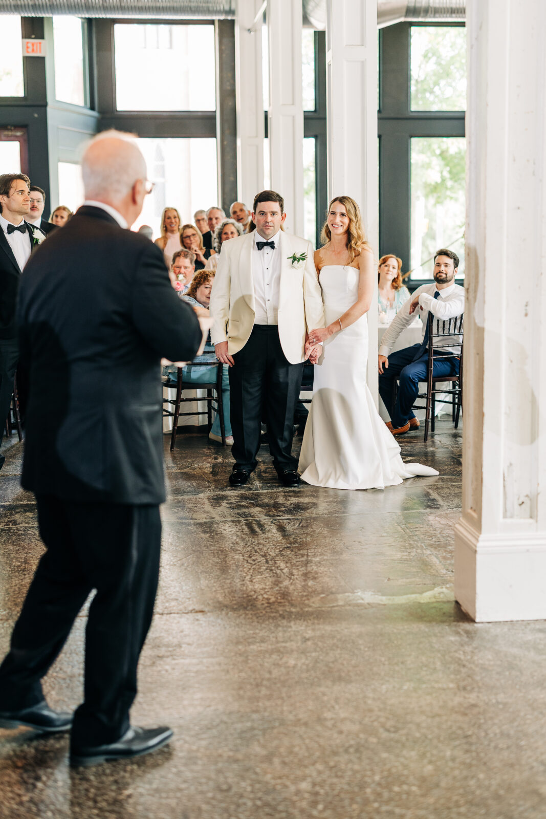 A newlywed couple, the groom in a white dinner jacket and the bride in a white strapless gown