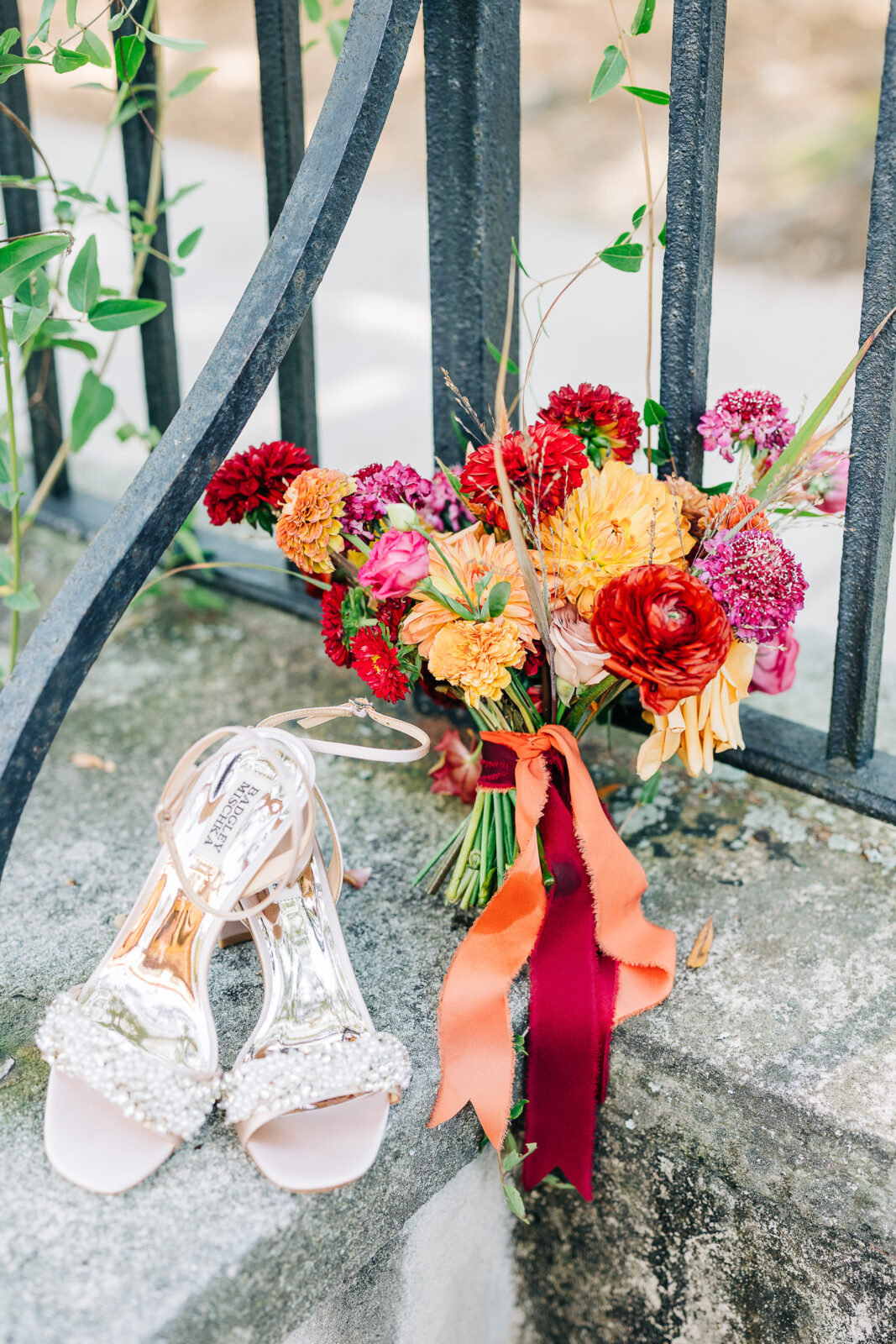Bride's jeweled wedding shoes and vibrant red, orange, and pink bouquet detail shot in Columbia, SC