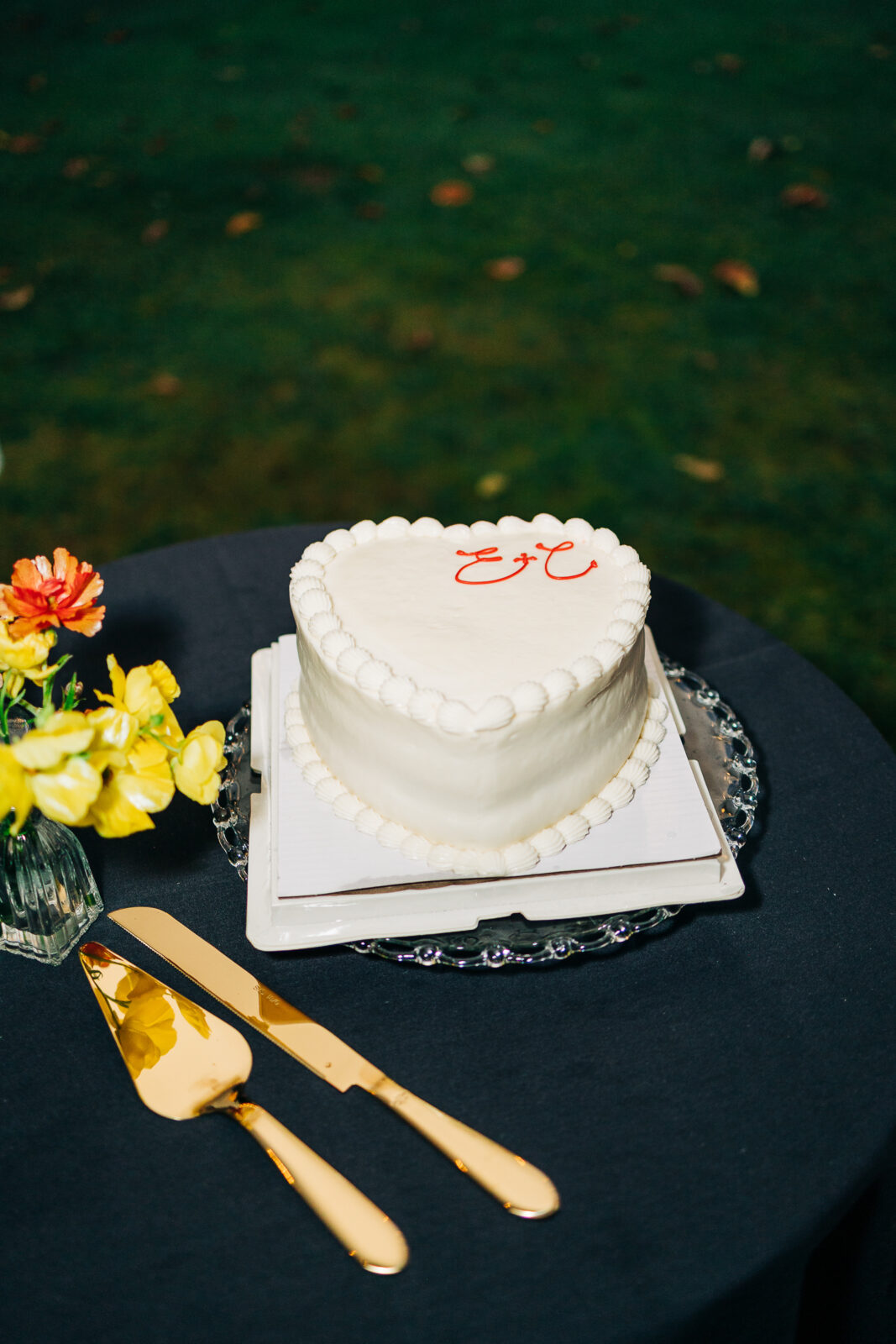 Heart-shaped wedding cake with gold serving set on a dark table at the Hampton-Preston Mansion reception