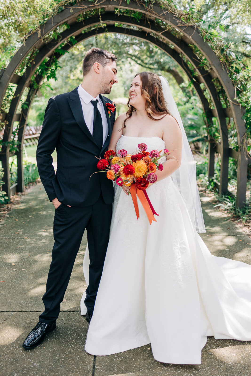 Bride and groom portrait with colorful bouquet under the wood archway at Hampton-Preston Mansion, Columbia, SC