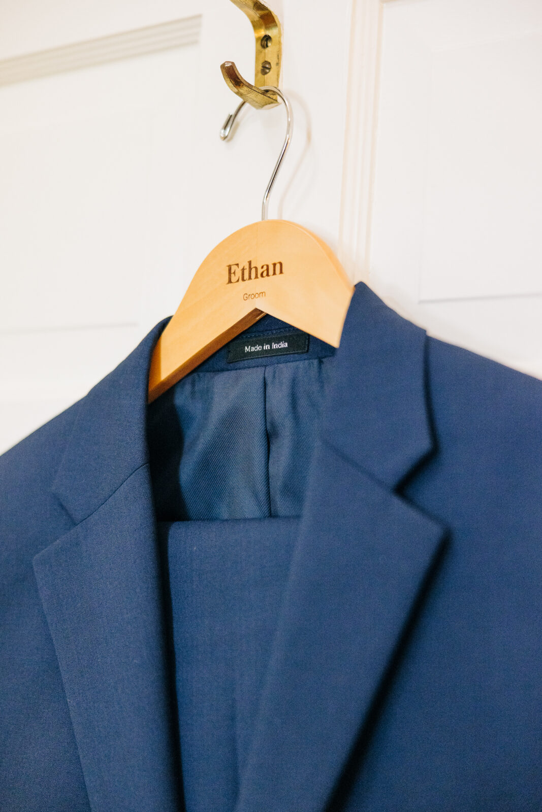 Groom's navy blue suit detail hanging on a personalized wooden hanger for the Columbia, SC wedding