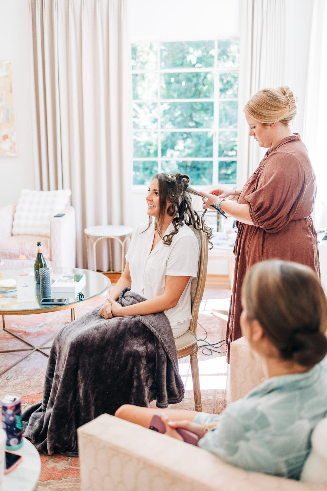 Bride getting ready with her hair stylist in a bright, sunlit room before the wedding ceremony in Columbia, SC