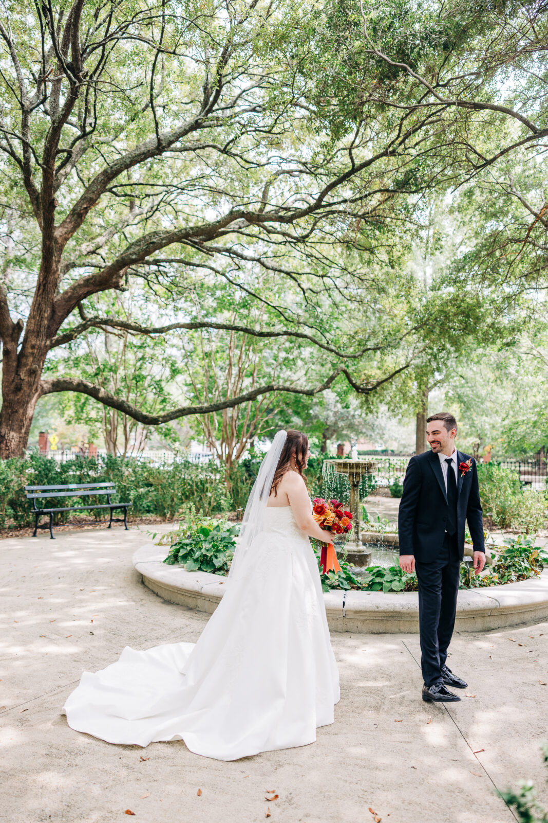 Joyful first look between bride and groom by the fountain in the Hampton-Preston Mansion Gardens, Columbia, SC