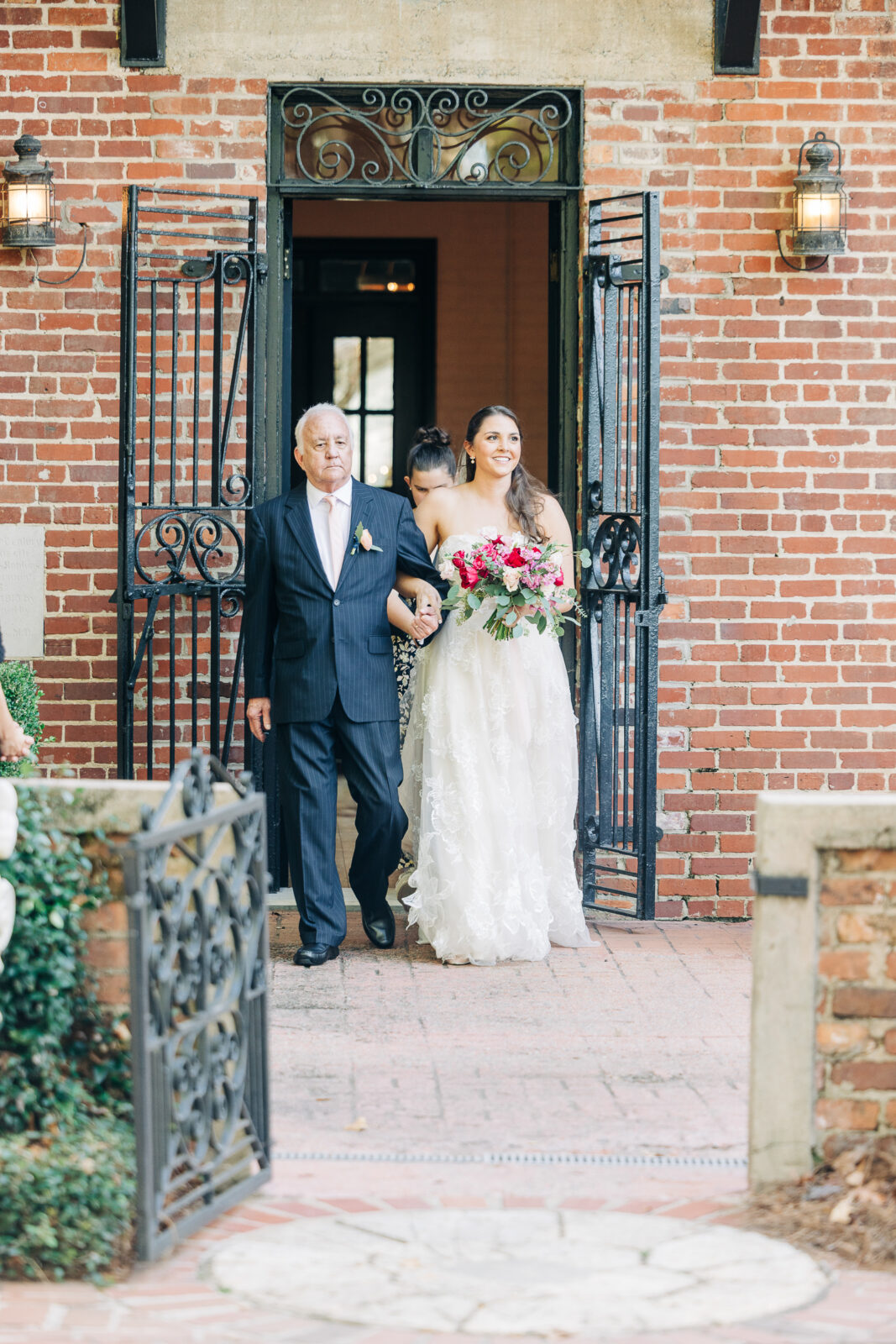 Bride being walked down the aisle by her father outside a historic brick building in Columbia, SC