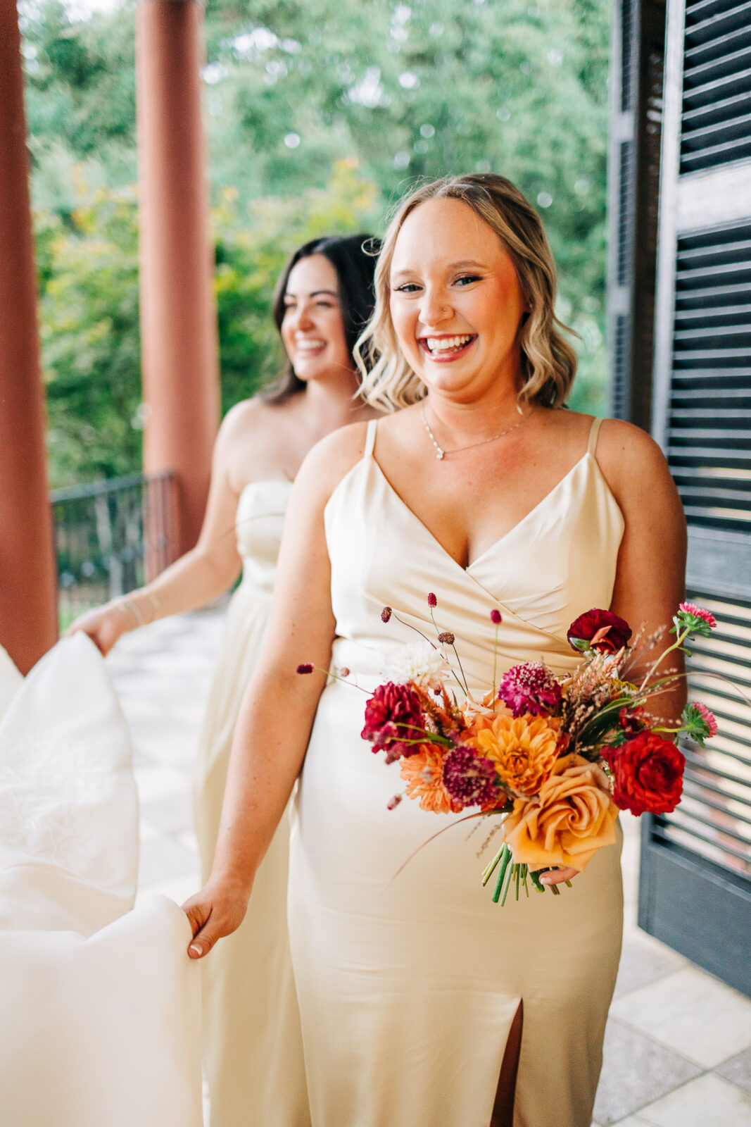 Smiling bridesmaid with colorful bouquet on the historic porch at Hampton-Preston Mansion, Columbia, SC