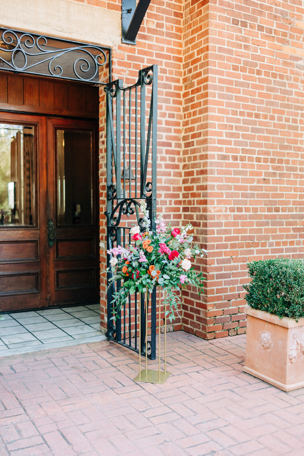 Wedding ceremony entrance with large floral arrangement at The Millstone at Adam’s Pond