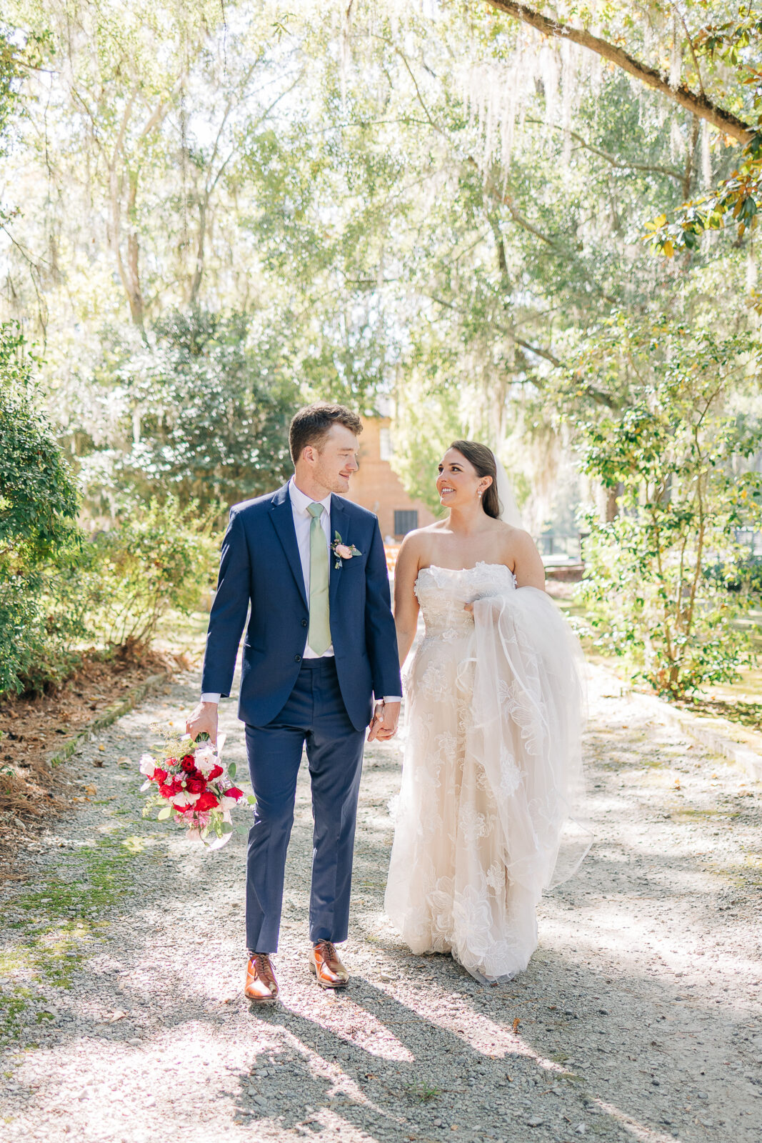Romantic portrait of the couple walking on the driveway under Spanish moss at The Millstone at Adams Pond