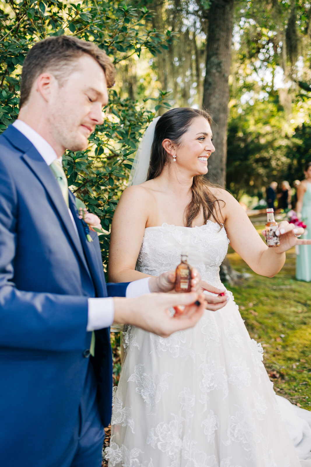 Bride and groom taking a celebratory shot or toast with mini liquor bottles during wedding photos in Columbia, SC.