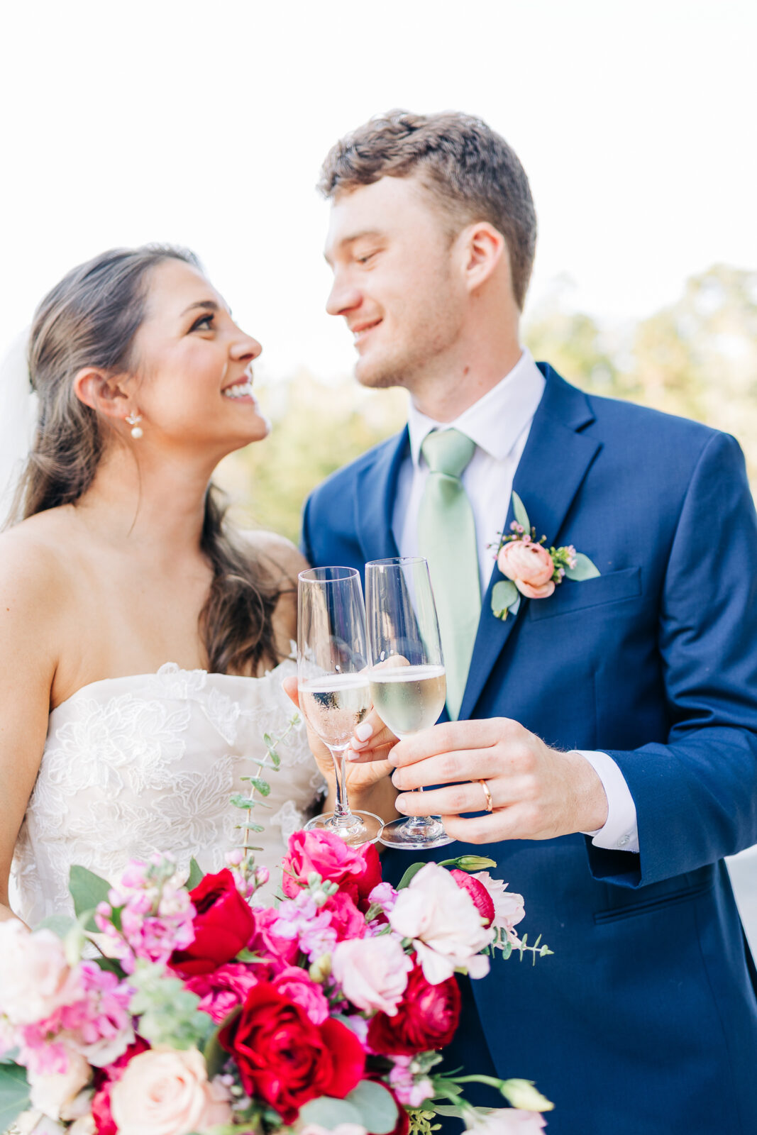 Couple toasting with champagne during outdoor wedding photos at The Millstone at Adams Pond