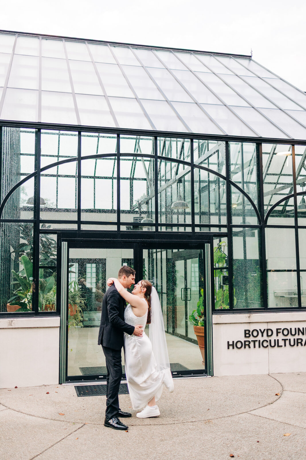 Bride and groom embracing outside the Boyd Foundation Horticultural Center greenhouse, Columbia, SC