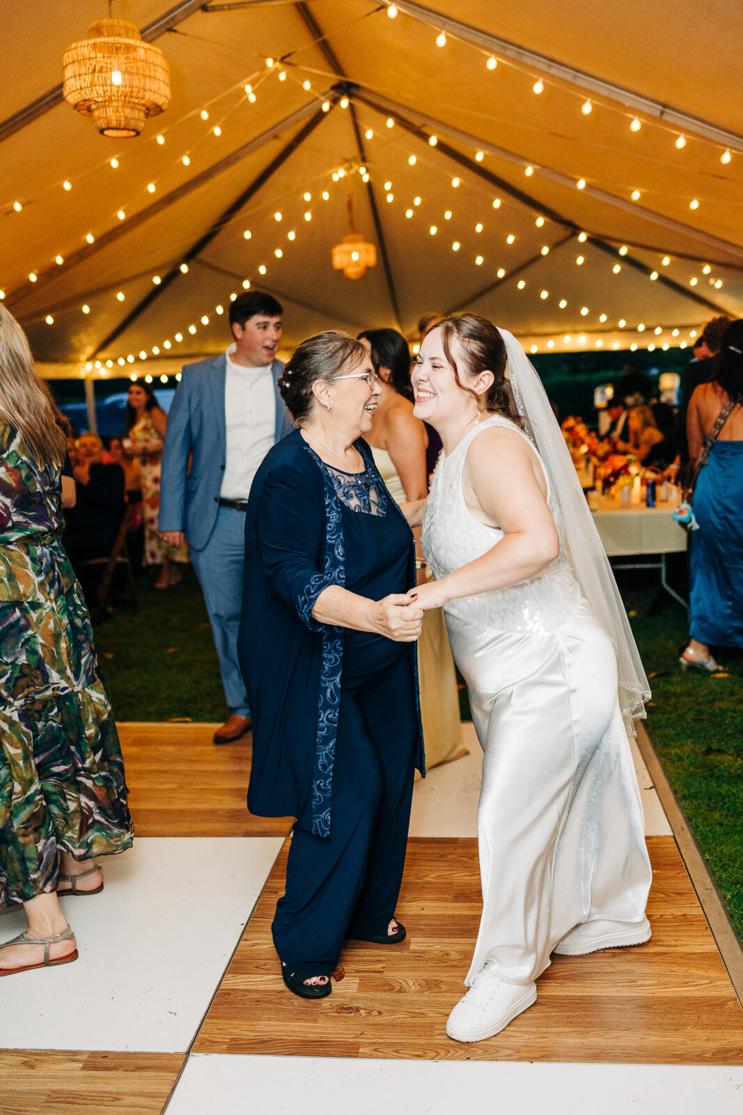 Bride and mother dancing under string lights on the tent dance floor at Hampton-Preston Mansion reception