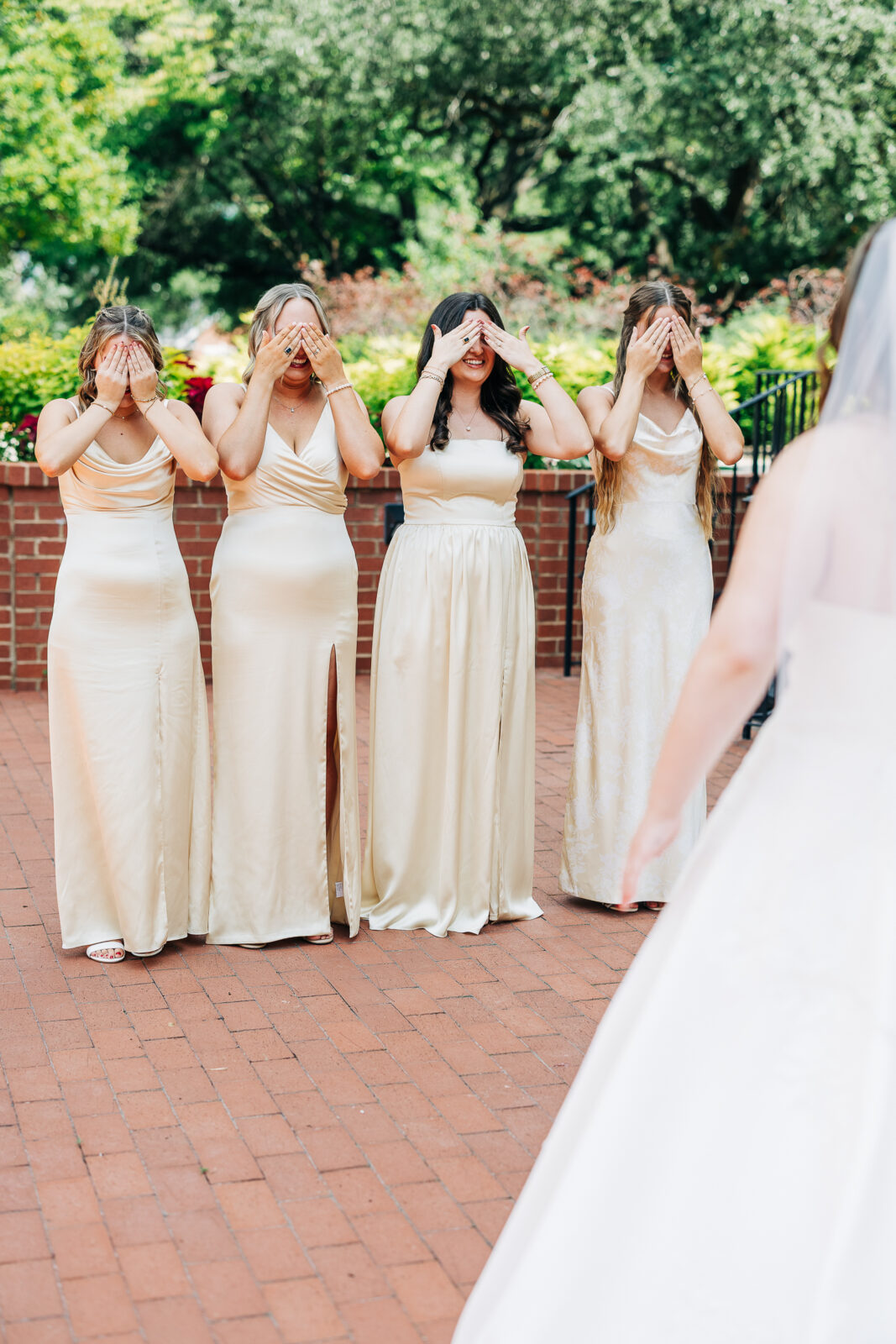 Smiling bride and groom wedding portrait holding vibrant red and orange bouquet at Hampton-Preston Mansion Gardens