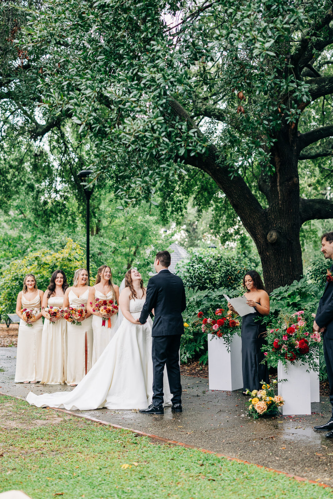 Joyful outdoor wedding ceremony with bride, groom, and bridesmaids under a large tree at Hampton-Preston Mansion, SC