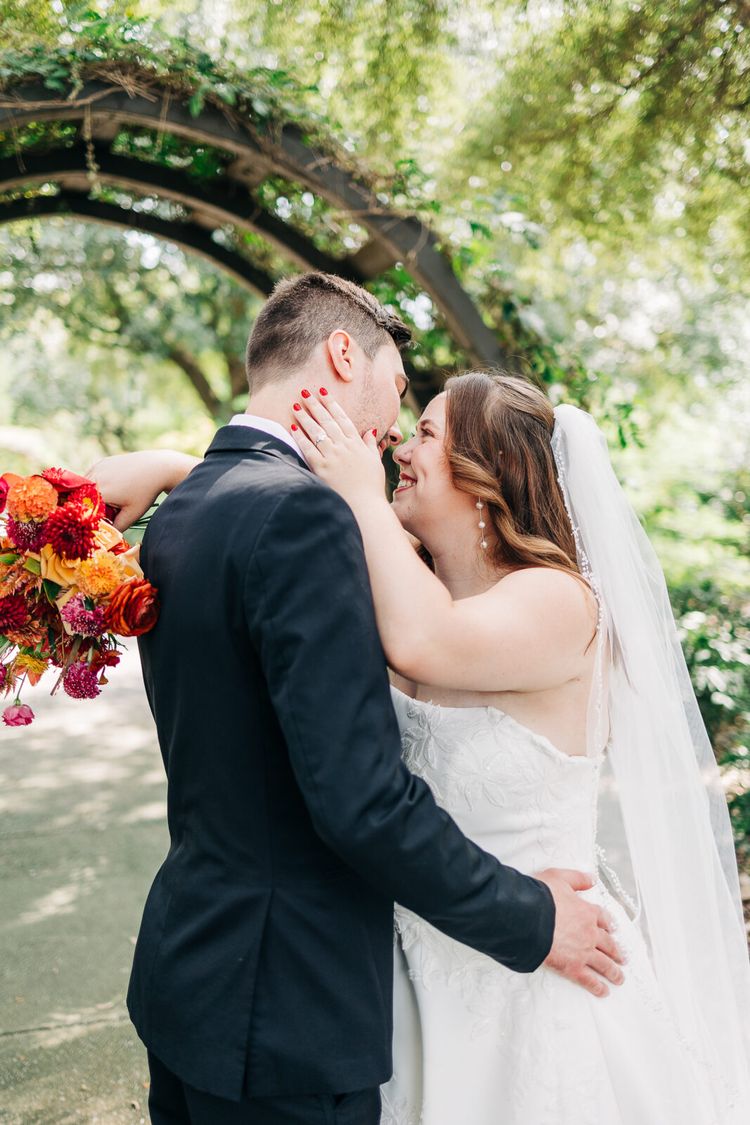Close-up of bride and groom embracing under a garden archway at Hampton-Preston Mansion, Columbia, SC