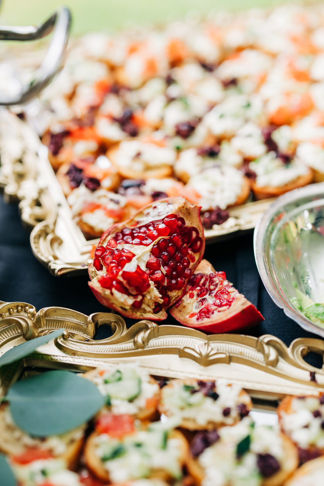 Close-up of wedding catering with pomegranate and crostini appetizers on gold trays in Columbia, SC