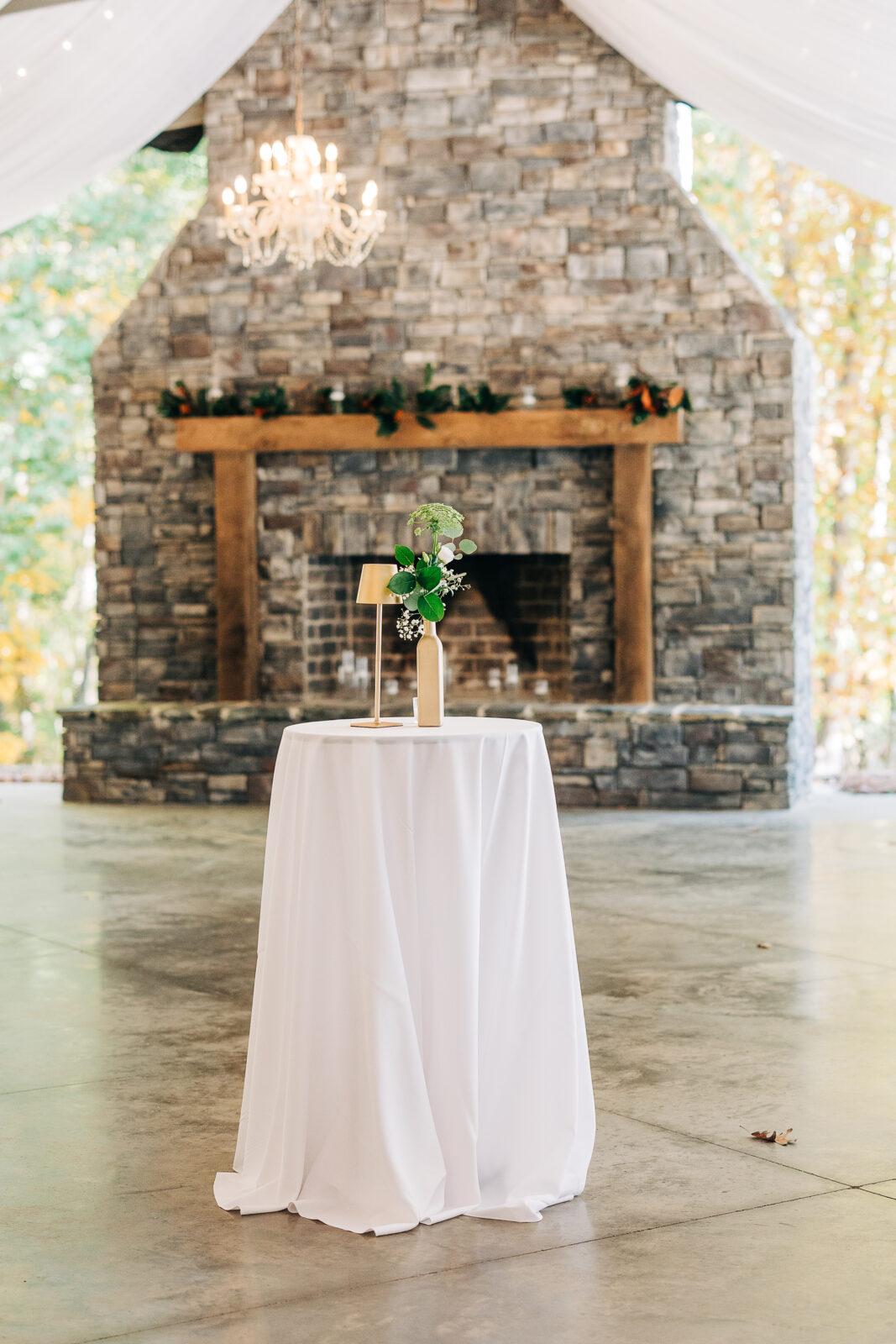 Cocktail hour table set up in front of the rustic stone fireplace at Oakbrook Farms