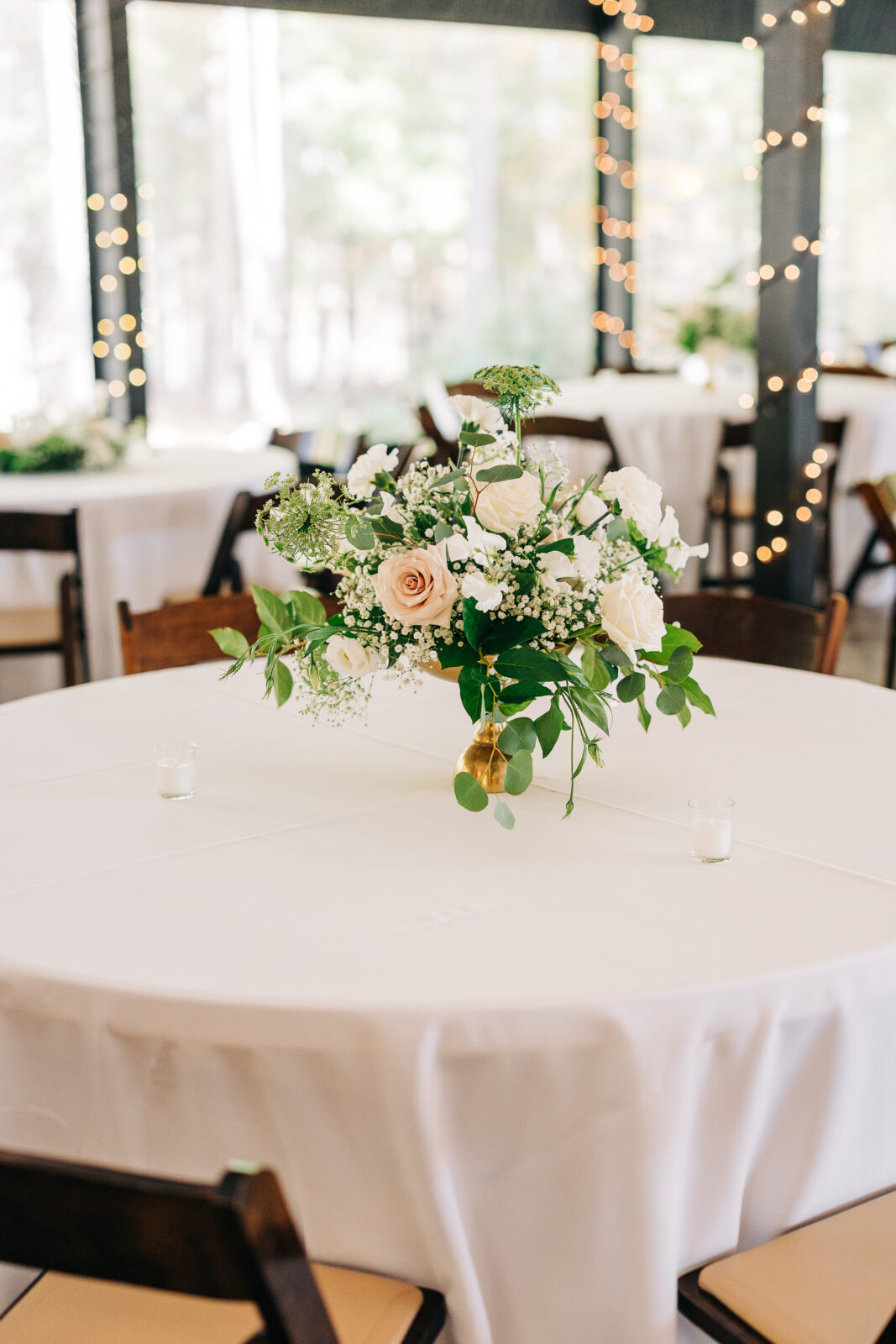 Reception table centerpiece with white roses and blush accents at Oakbrook Farms Wedding South Carolina