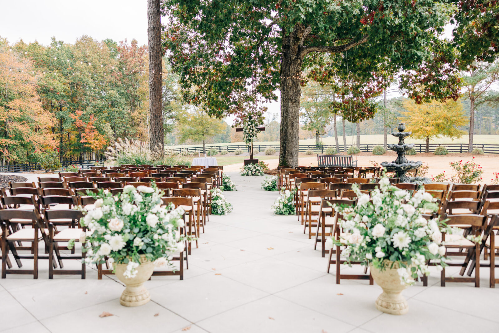 Outdoor wedding ceremony setup with wooden chairs and floral urns at Oakbrook Farms South Carolina