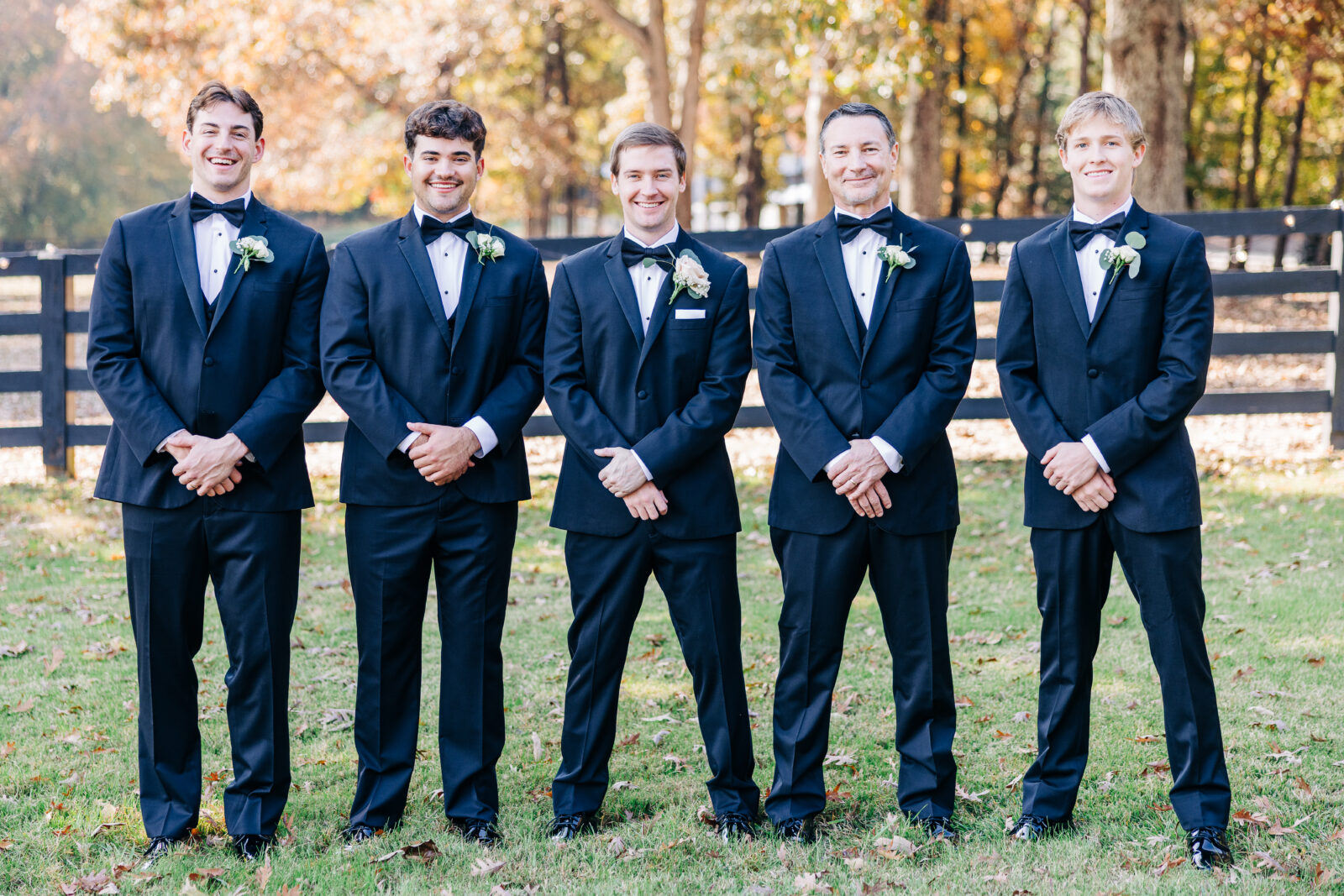 Groom and groomsmen posing formally in black tuxedos at Oakbrook Farms Wedding South Carolina