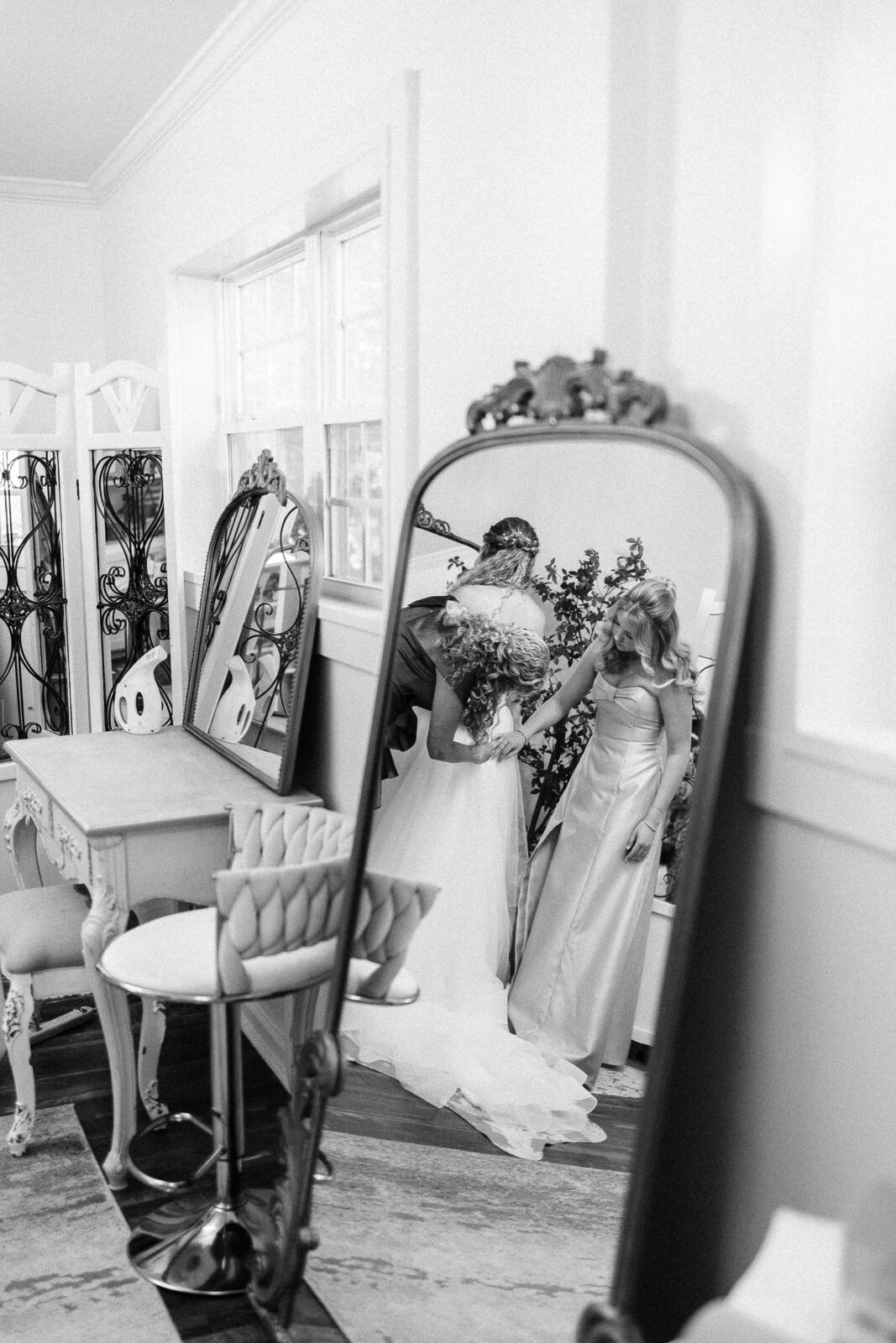 Black and white mirror reflection of bride with bouquet in elegant getting ready room