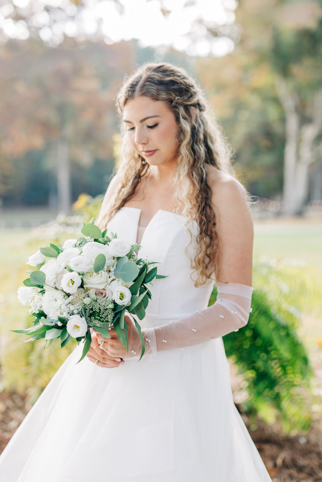 Close-up portrait of the bride with white bouquet and pearl-detailed gloves at Oakbrook Farms