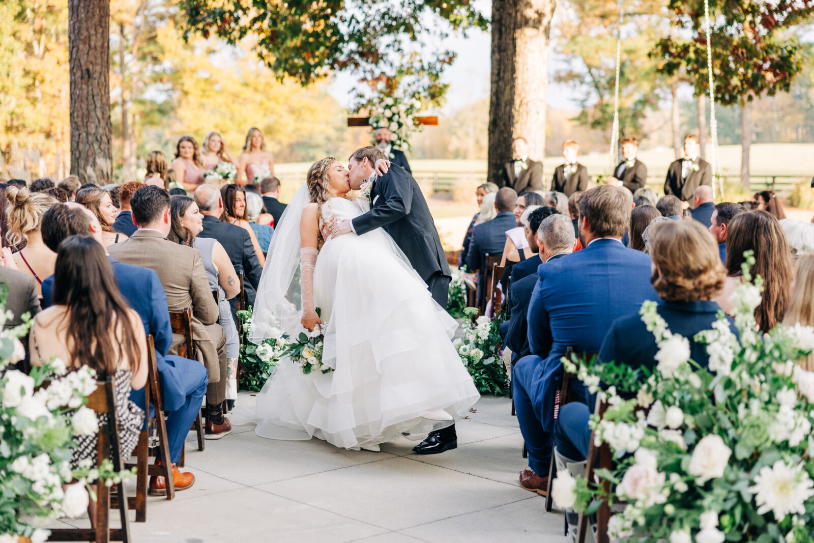 First kiss photo at the Oakbrook Farms Wedding South Carolina ceremony with guests looking on