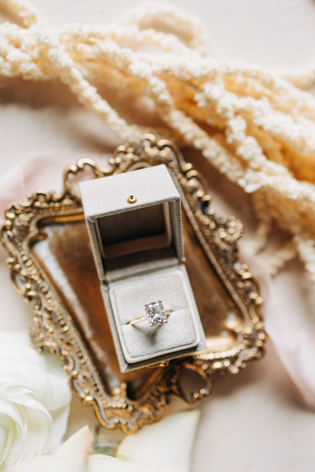 Engagement ring detail photo in a velvet box on a vintage gold tray