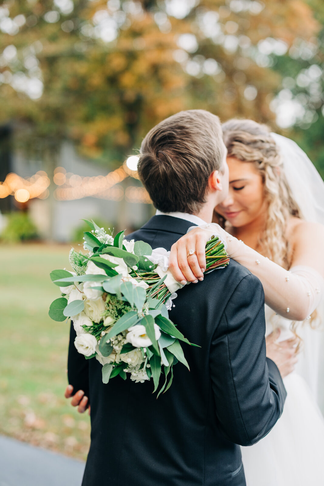 Bride and groom embracing with white floral bouquet at Oakbrook Farms Southern Wedding