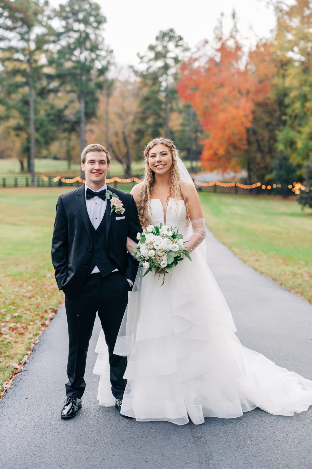 Sarah and Thomas wedding portrait on paved path at Oakbrook Farms Southern Wedding