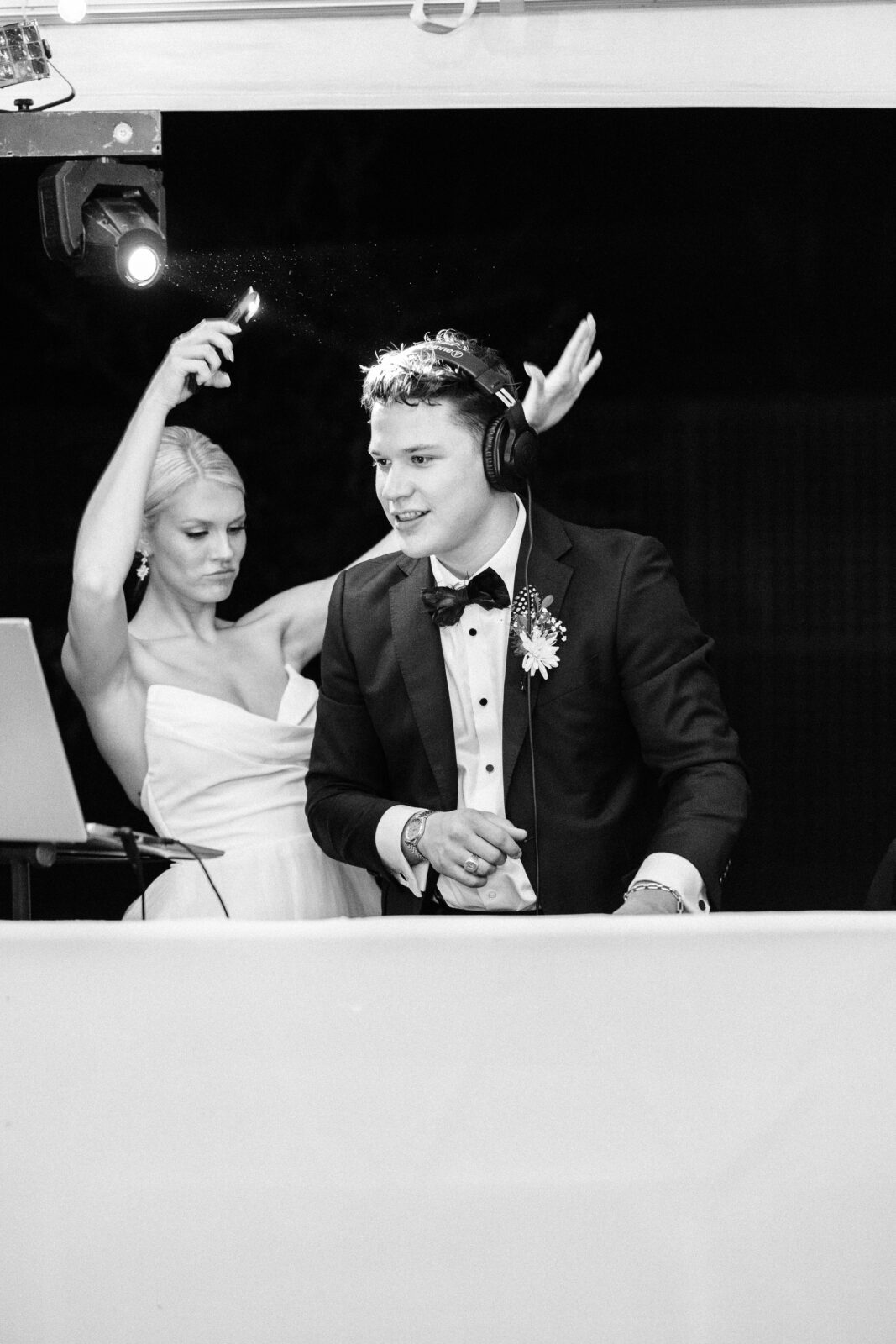 Black and white candid photo of the groom wearing headphones