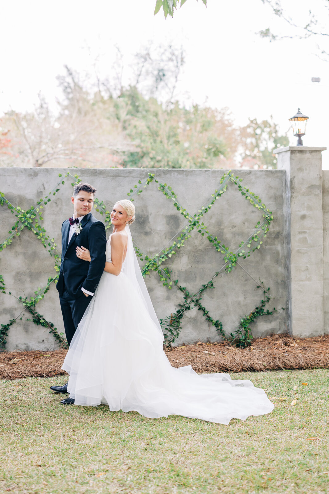 Flat lay of the couple's black and white wedding invitation suite, gold earrings, and wedding rings on a velvet box, draped with sheer fabric, highlighting the Hartley House Wedding South Carolina date