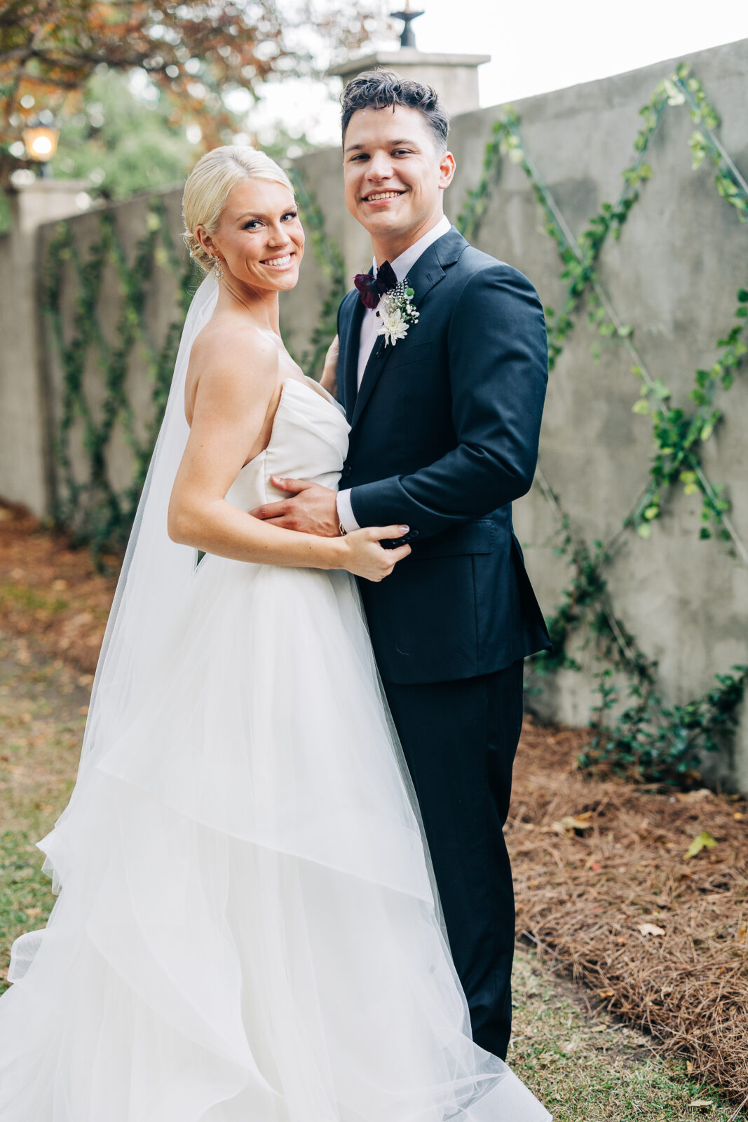 Close-up of the happy bride and groom embracing and smiling at the camera during their portrait session at the Hartley House Wedding South Carolina venue