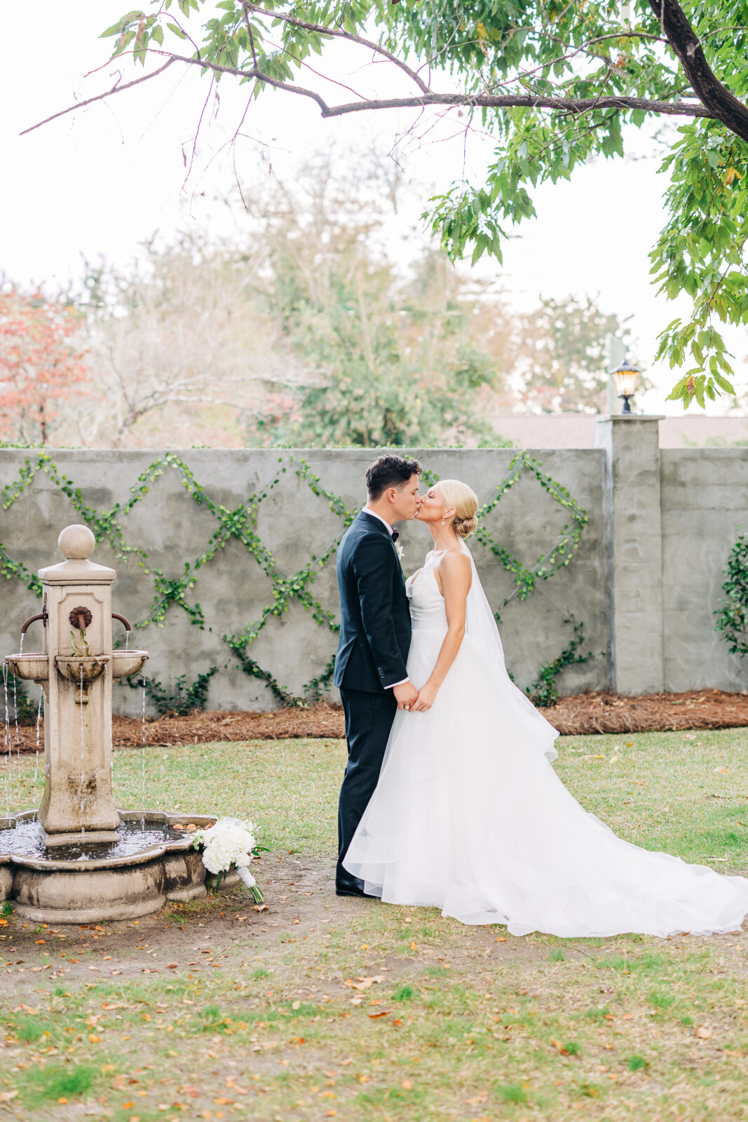 Romantic portrait of the bride holding the groom's arm and looking at him lovingly outdoors