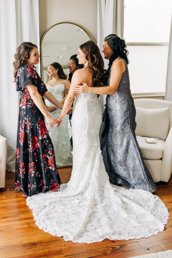 Bride getting ready with her mom and bridesmaid during a multicultural wedding morning.