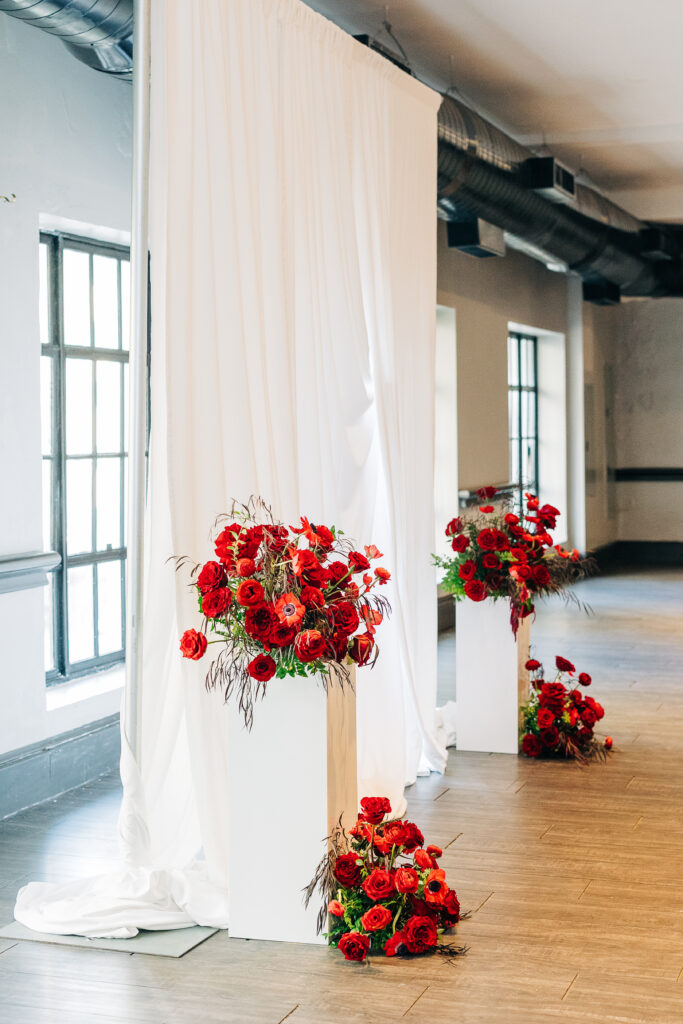 stunning red flower wedding arrangements at the center of the ceremony