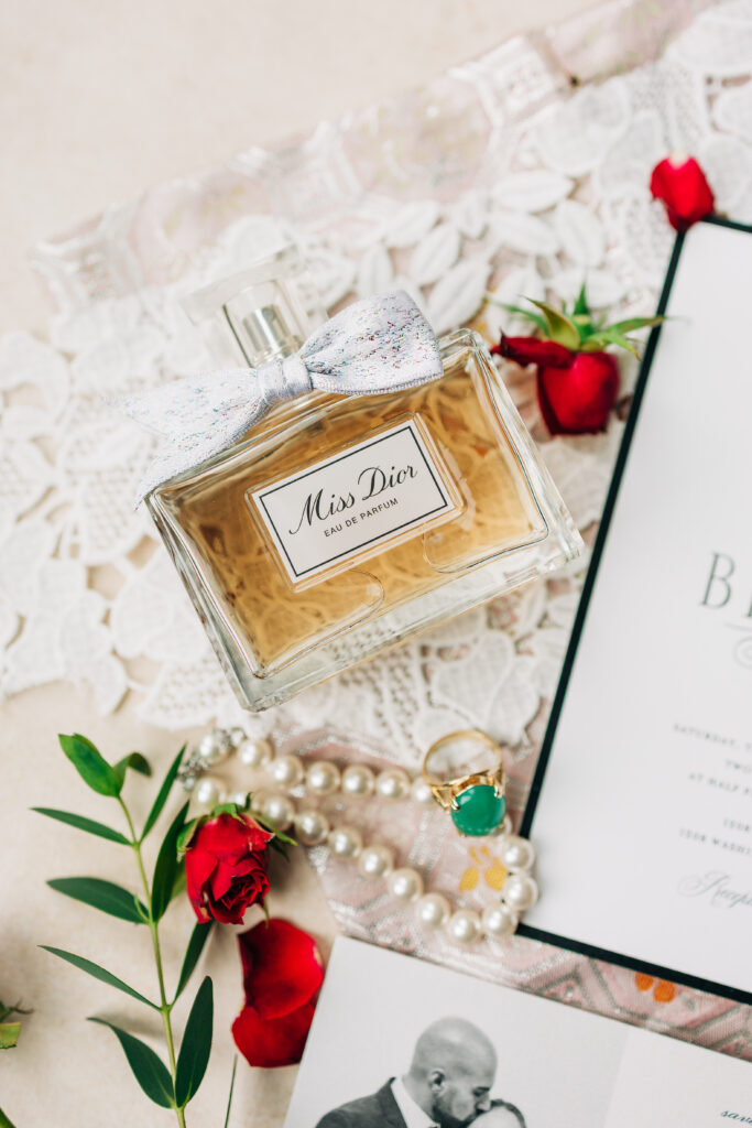 Miss Dior perfume bottle styled with pearls, florals, and lace for a South Carolina wedding detail photo.