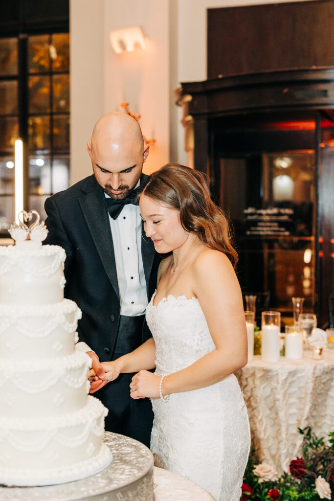 Emily and Bradley cutting their wedding cake together during their reception at 1208 Washington Place.