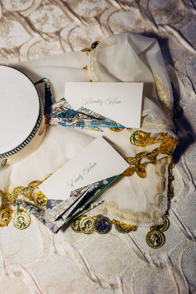 Close-up of handcrafted origami crane place cards featuring the couple’s names at a multicultural celebration.