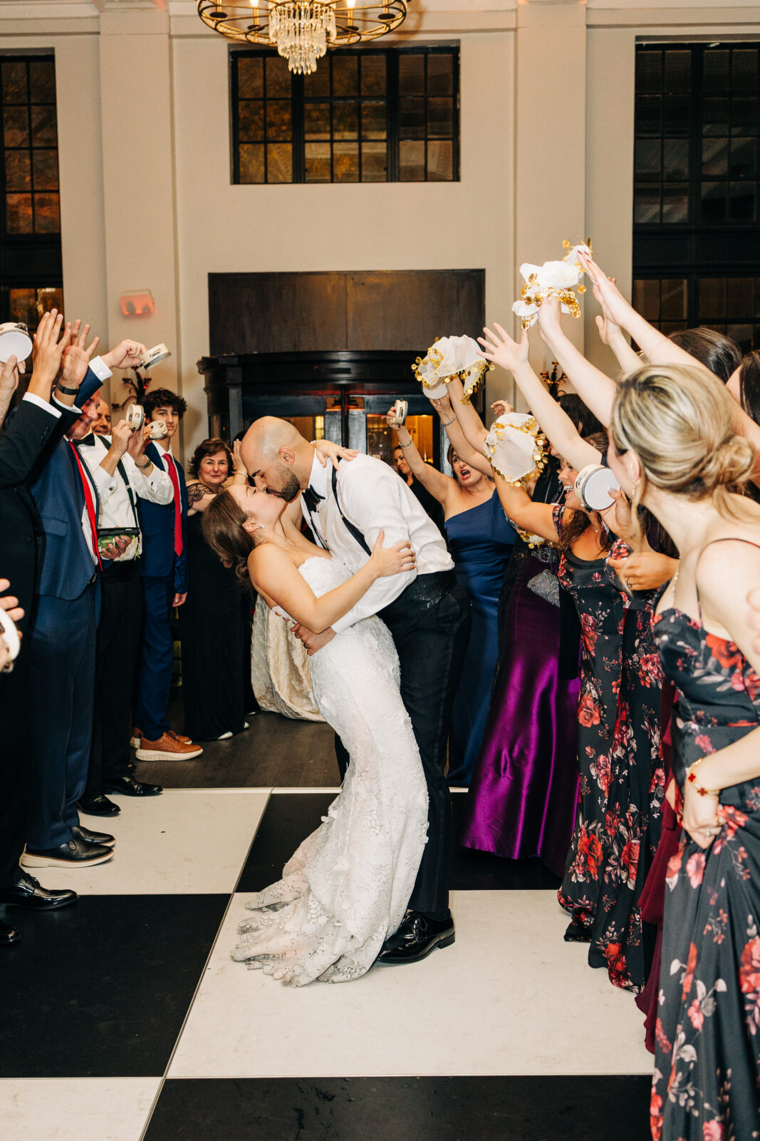 Bride and groom kissing during their reception exit surrounded by cheering guests at a South Carolina wedding.