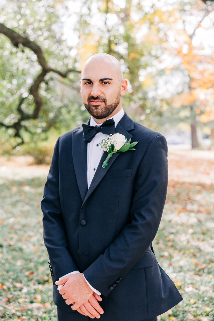 Groom portrait outdoors in Columbia, SC, wearing a black tuxedo and white boutonniere.