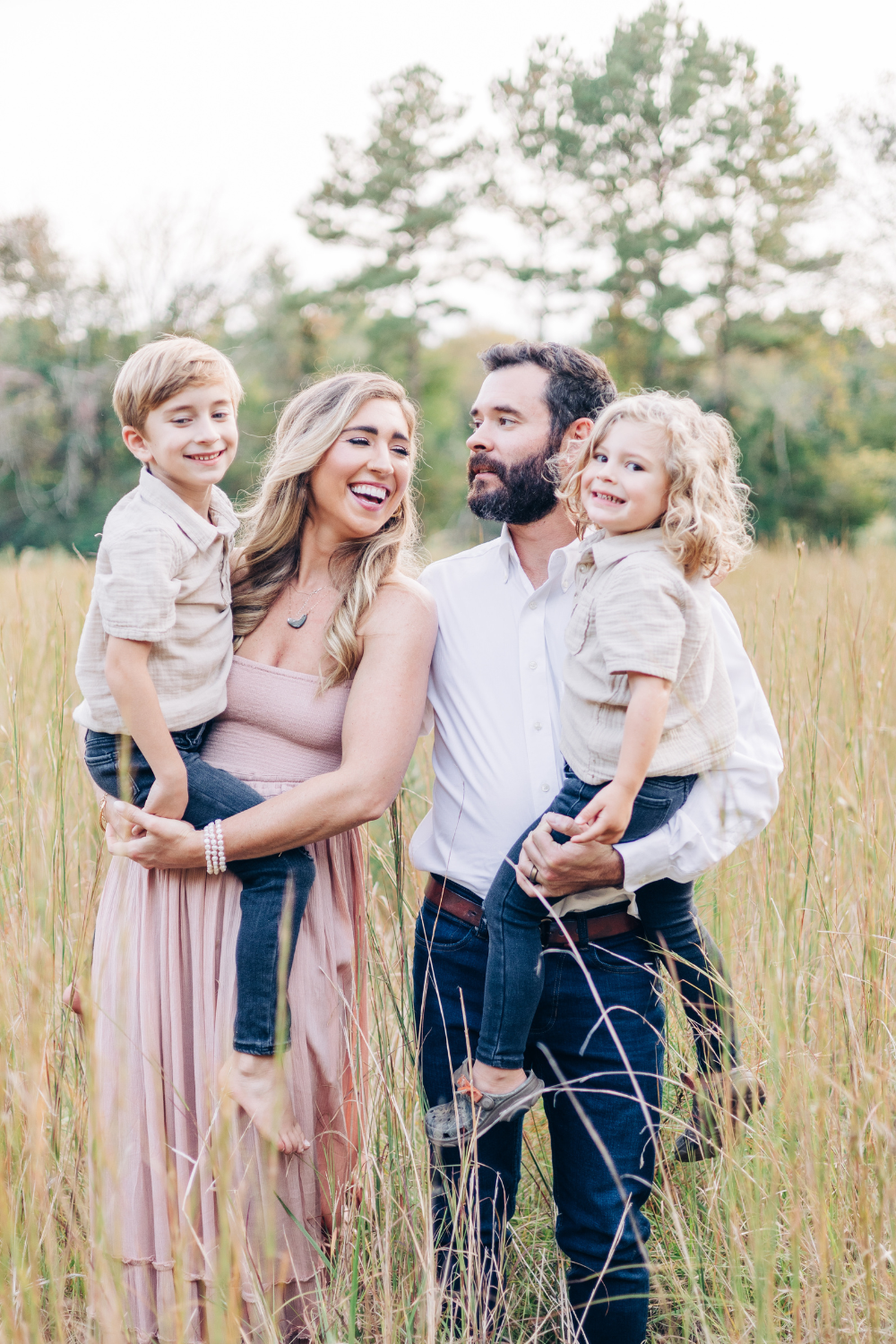Family of five wearing neutral tones during an outdoor South Carolina family photography session in a grassy field